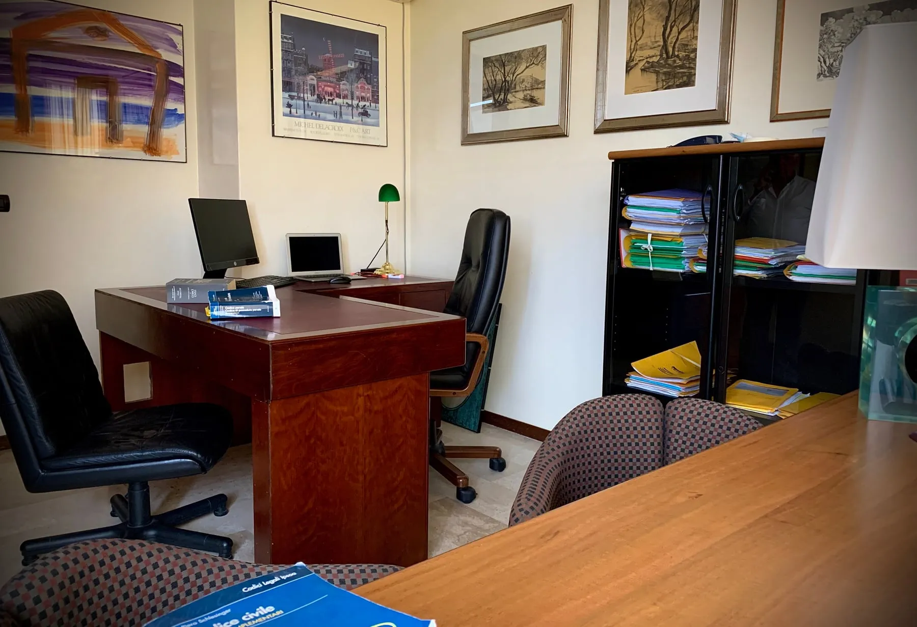L'interno dello studio: la scrivania con i codici, le poltrone e l'armadio dei fascicoli.